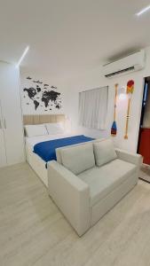 a bedroom with a bed and a white couch at Luxuoso flat familiar beira lago in Brasilia