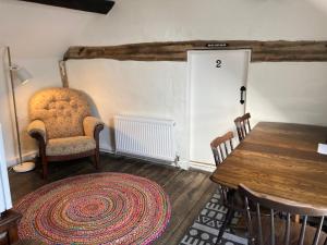 um quarto com uma mesa, uma cadeira e uma porta em Bryntirion Farmhouse Rooms (with bathroom) em Llanfair Caereinion
