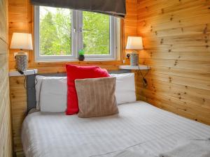 a bedroom with wooden walls and a bed with red pillows at Halifax - Uk47056 in Holme upon Spalding Moor