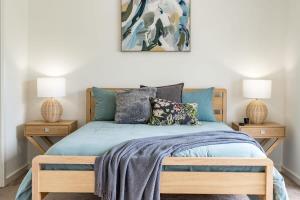 um quarto com uma cama com lençóis azuis e 2 candeeiros em 72 Seagull Ave Chiton - BYO Linen em Hayborough