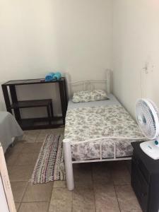 a small bedroom with a bed and a desk at Hostel Dourado in Barra do Garças +26 photos