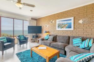 埃利奥特港Knights View - 2 14 Merrilli - BYO Linen - Wi-Fi - Beachfront的带沙发、椅子和电视的客厅