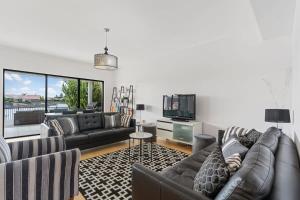 a living room with two couches and a tv at Lakehouse28 Waterfront Resort Living Encounter Bay - BYO Linen in Encounter Bay