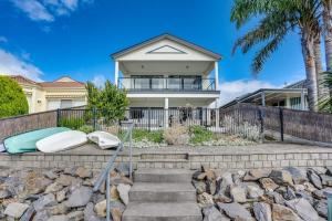 a house with two surfboards sitting on the steps at Lakehouse28 Waterfront Resort Living Encounter Bay - BYO Linen in Encounter Bay