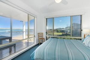a bedroom with a large bed and a view of the ocean at Beladura - 35 Goolwa Channel Drive Hindmarsh Island - Linen Included in Hindmarsh Island