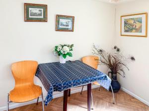 a dining room table with two chairs and a vase of flowers at St Annes Road in Torquay