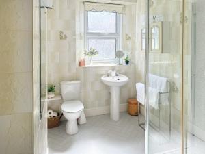 La salle de bains est pourvue de toilettes, d'un lavabo et d'une douche. dans l'établissement St Annes Road, à Torquay