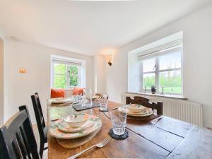 a dining room with a wooden table and chairs at Oasis Cottage in Broughton Gifford