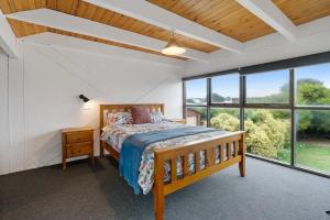 a bedroom with a bed and a large window at The Glass House 103 Bristow-Smith Ave Goolwa South - BYO Linen in Goolwa South