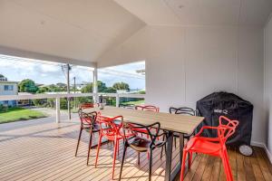 a dining room with a wooden table and red chairs at 5 Tabernacle Rd Encounter Bay- No Linen Included in Encounter Bay