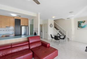 a living room with a red couch and a kitchen at T2 12 Wentworth Pde Hindmarsh Island - No Linen Included in Hindmarsh Island