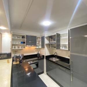 a kitchen with black counters and stainless steel appliances at Luxury Marina Appartement Agadir in Agadir