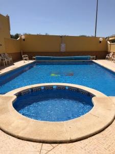 uma grande piscina de água com cadeiras à volta em Home S&F- Algorfa em Algorfa