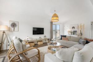 a living room with white furniture and a tv at 32 Beach Rd Goolwa South-No Linen Included in Goolwa South