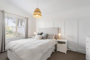 a white bedroom with a large bed and a window at 32 Beach Rd Goolwa South-No Linen Included in Goolwa South