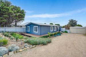 una casa azul con un jardín frente a ella en 32 Beach Rd Goolwa South-No Linen Included, en Goolwa South