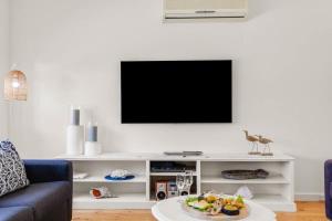 a living room with a tv on a white entertainment center at 18 Strangways Tce Port Elliot - Linen Included in Port Elliot