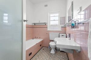 een badkamer met een wastafel, een toilet en een bad bij 18 Strangways Tce Port Elliot - Linen Included in Port Elliot