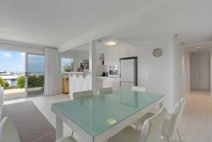 Una cocina y un comedor con una mesa de cristal y sillas. en 48 Hero Ave Middleton, en Middleton