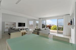 Una sala de estar blanca con una gran mesa de cristal. en 48 Hero Ave Middleton, en Middleton