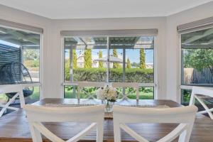 Un comedor con una mesa y sillas blancas. en Hidden Little Gem - Township - Luxury - Linen Included, en Middleton
