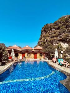 une piscine dans un complexe avec une montagne en arrière-plan dans l'établissement Trang An Mountain House, à Ninh Binh