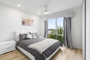 a bedroom with a bed and a large window at Serendipity - 27 Shields Crs Encounter Bay - No Linen Included in Encounter Bay