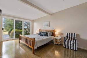 a bedroom with a bed and a chair in it at 8 Wright Tce Encounter Bay - No Linen Included in Encounter Bay