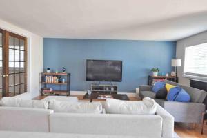 a living room with two white couches and a flat screen tv at Housepitality - Top Choice Flat - Location in Columbus