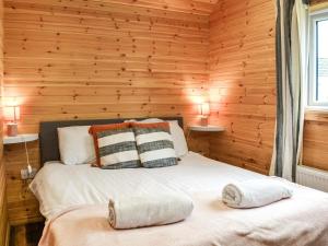 a bedroom with wooden walls and a bed with two pillows at Wellington - Uk47055 in Holme upon Spalding Moor