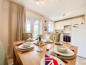 a kitchen with a wooden table with chairs and a refrigerator at St, Andrews Mews in Wells