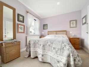 Un dormitorio con una cama con una manta de flores y una ventana en St, Andrews Mews en Wells