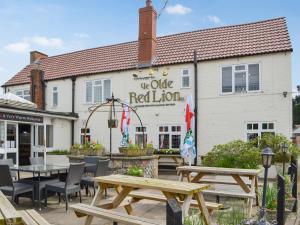 a white building with tables and chairs in front of it at Wellington - Uk47055 in Holme upon Spalding Moor