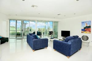 Sala de estar con 2 sillas azules y TV en Gallery 7 - Town Centre - Wi-Fi - Linen Included, en Victor Harbor