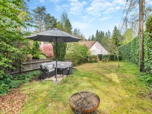 a patio with an umbrella and a chair and a table at The Wabi-sabi Sanctuary in Arford