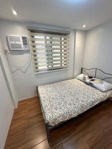 een kleine slaapkamer met een bed en een raam bij Fully Furnished 2 BR w/ Netflix in Abucay
