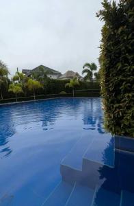 een groot blauw zwembad voor een huis bij Fully Furnished 2 BR w/ Netflix in Abucay