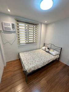 een slaapkamer met een bed, een ventilator en een raam bij Fully Furnished 2 BR w/ Netflix in Abucay