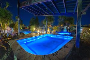 una piscina con iluminación azul por la noche en Tasman Holiday Parks - Rotorua en Rotorua