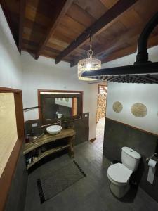 a bathroom with a toilet and a sink and a mirror at El Retiro De Carolina in Santa Marta