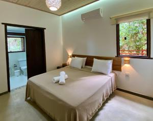 un osito de peluche blanco sentado en una cama en un dormitorio en Pousada Panorama Cipo en Santana do Riacho