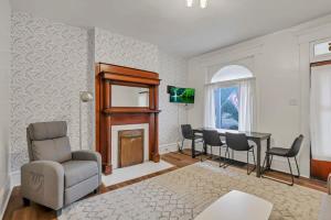 a living room with a fireplace and a table and chairs at Housepitality - The City Gateway in Columbus