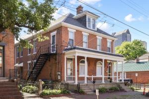 a red brick house with a staircase in front of it at Housepitality - The City Gateway in Columbus