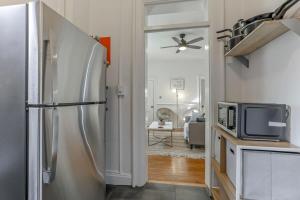 a kitchen with a refrigerator and a living room at Housepitality - The Short North Sanctuary in Columbus