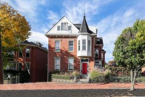 a red brick house with a white roof at Housepitality - The Capital House - 5 BR Downtown in Columbus