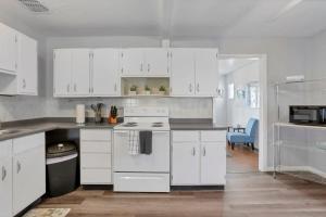 cocina con armarios blancos y fogones en Housepitality - West Side Lodge - 6 BR 2 BA, en Columbus