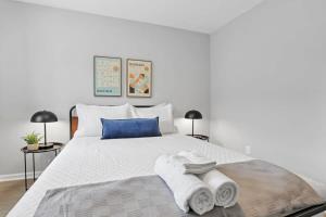 a bedroom with a white bed with towels on it at The Schumacher Townhouse - 2 BR in Columbus