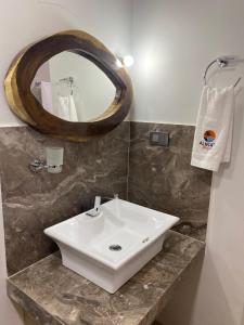 a bathroom with a white sink and a mirror at Hotel Alikaa Wayira in Ríohacha