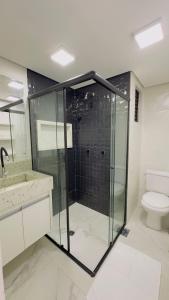 een badkamer met een glazen douche en een toilet bij Flat 135 beira lago em Brasília in Brasilia