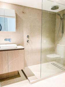 een badkamer met een douche en een wastafel bij Regatta Noosa in Noosaville